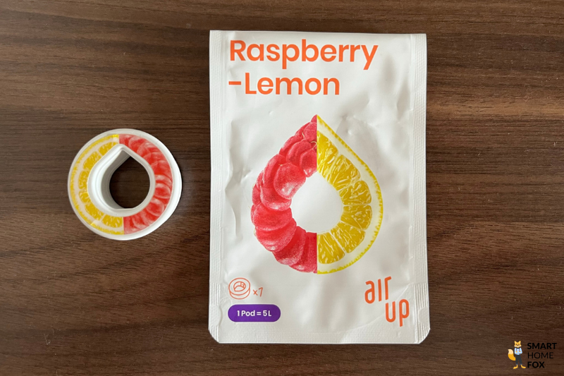 Ein Bild, welches den Pod und die Verpackung des Geschmacks Raspberry-Lemon zeigt.